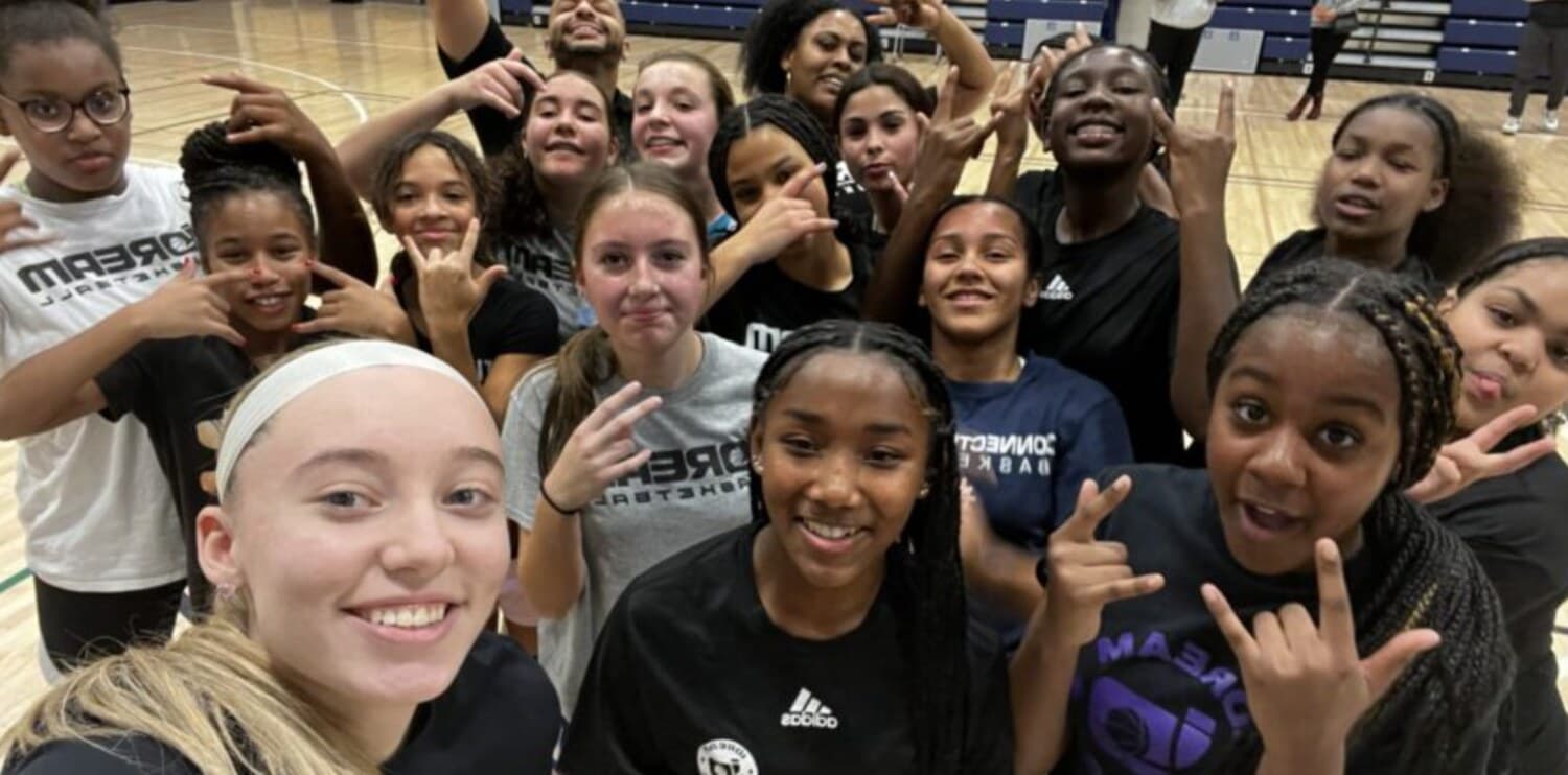 A girls' youth basketball team celebrating together after practice